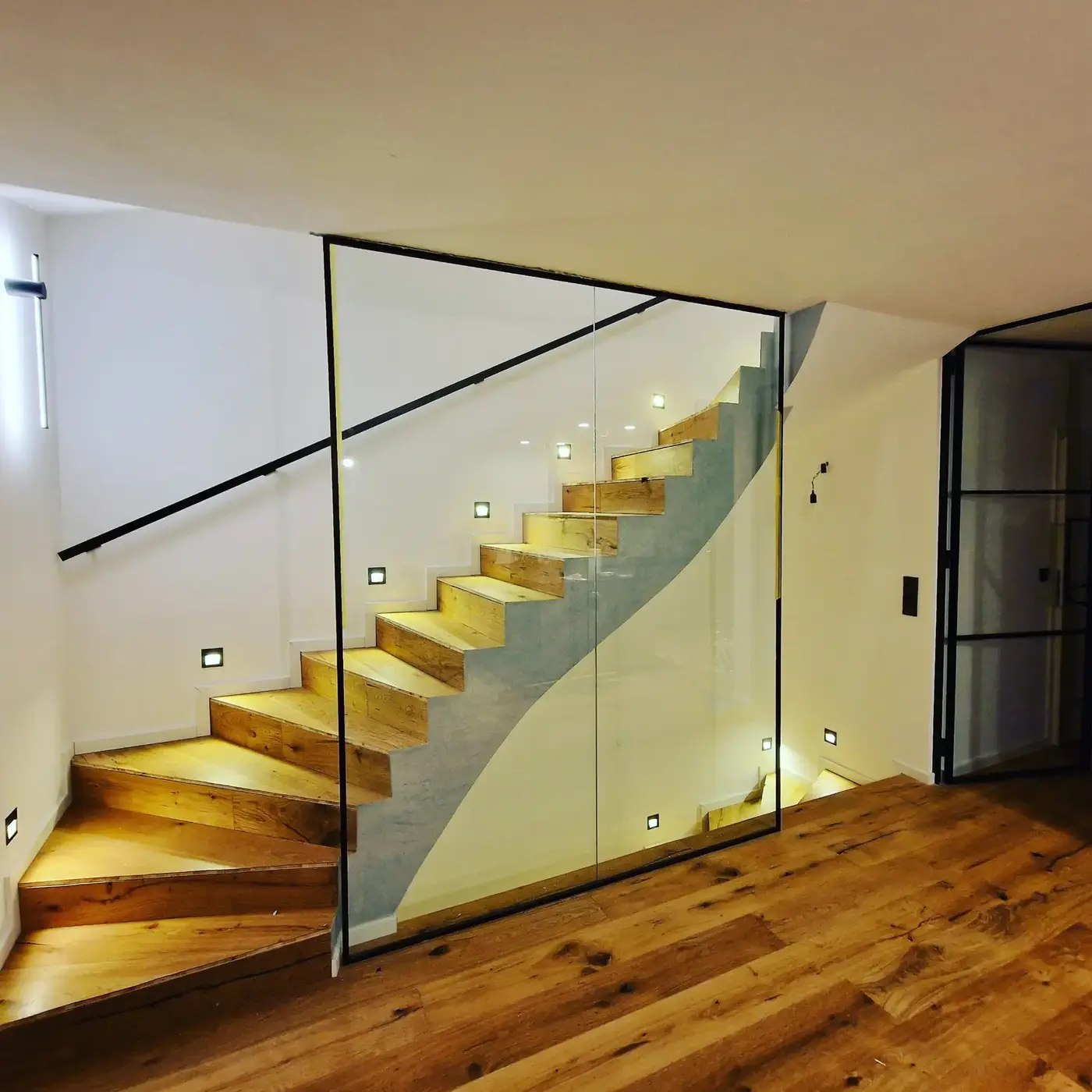 Von myImmoBau realisierte Holztreppe mit Glasgeländer und Stufenbeleuchtung